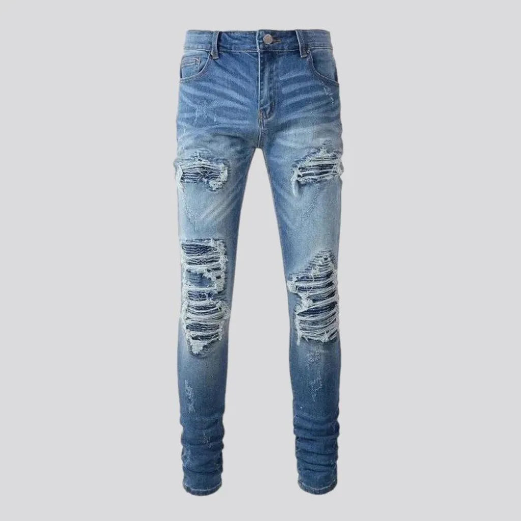 Damaged men's whiskered jeans